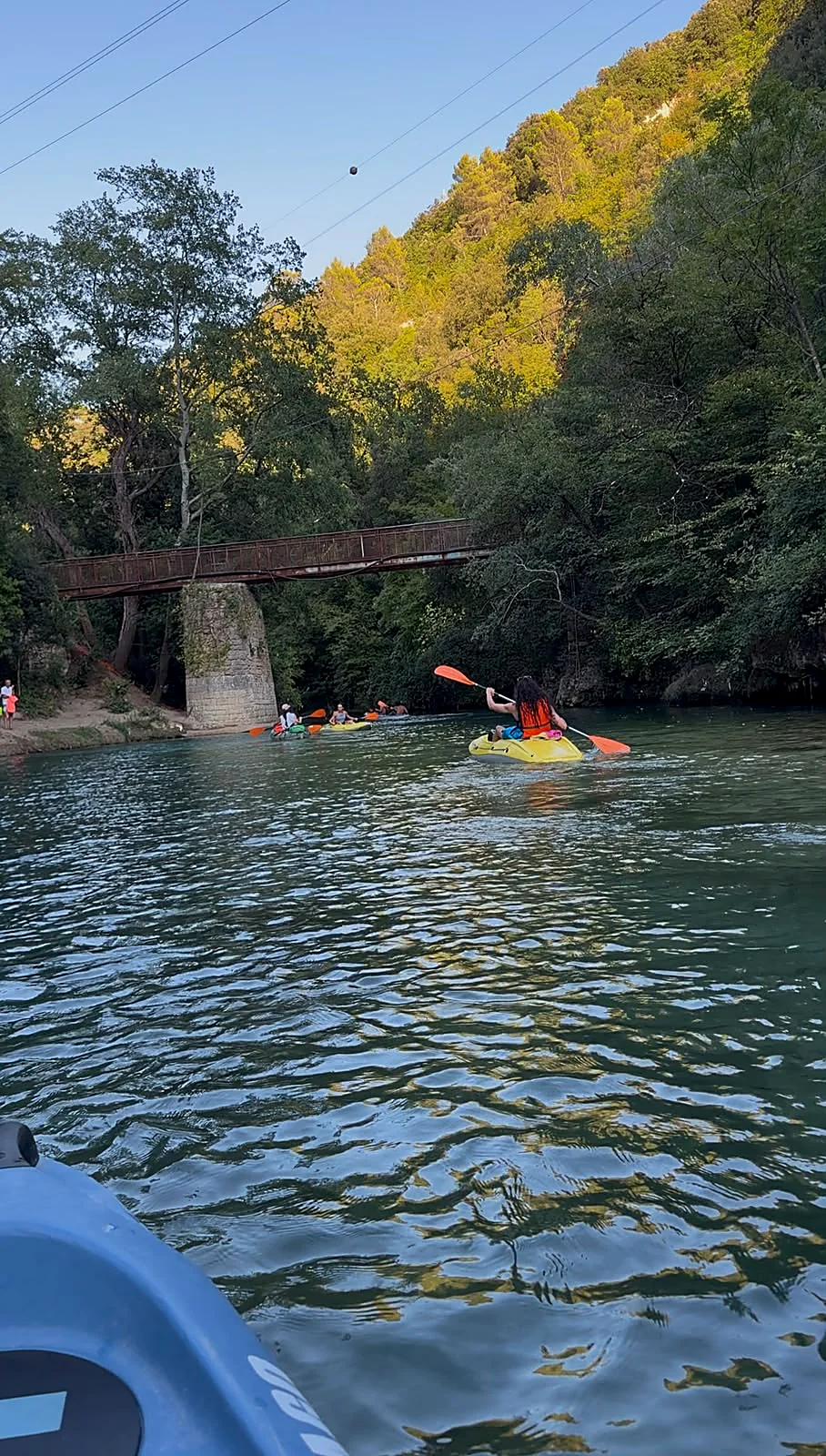 Kayaker sotto il vecchio ponte in ferro tra la vegetazione rigogliosa delle Gole del Nera